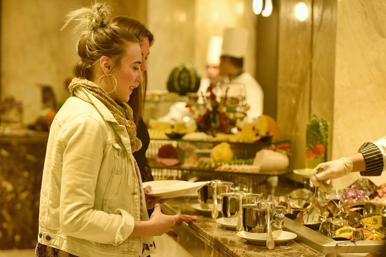 מלון עיין סוחנה Grand Ocean El Sokhna מראה חיצוני תמונה A woman selecting food from a buffet